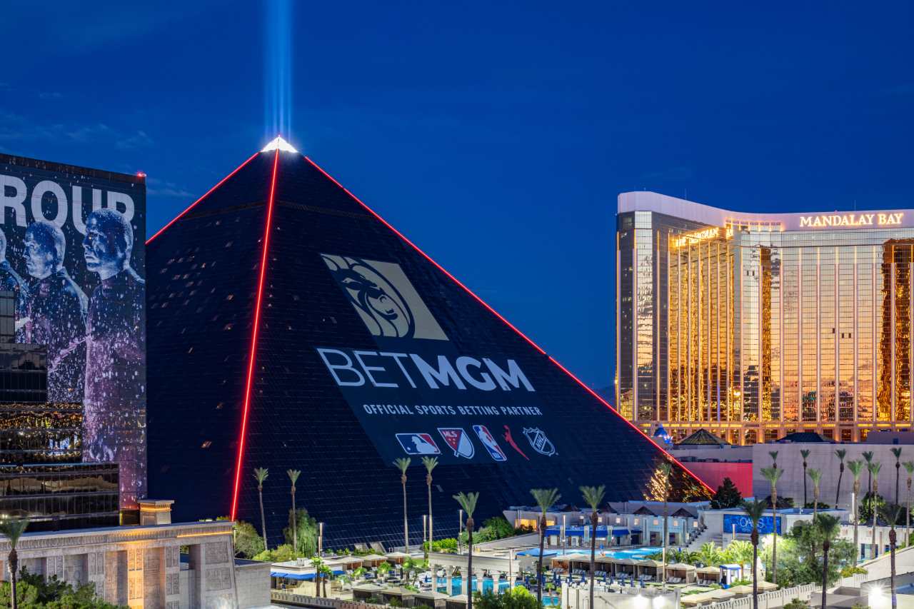 The new BetMGM ad wrap on the Luxor hotel in the evening with red lighting.