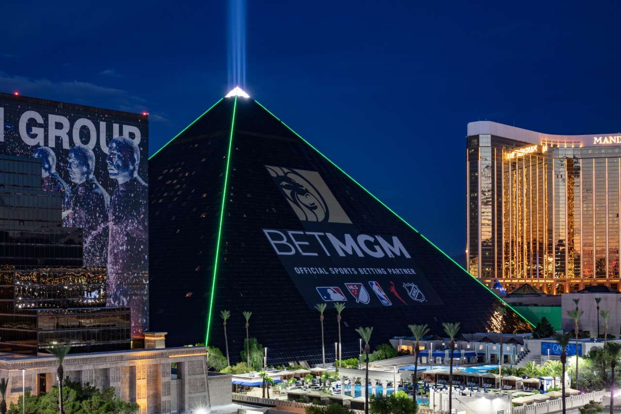 The new BetMGM ad wrap on the Luxor hotel in the evening with green lighting.