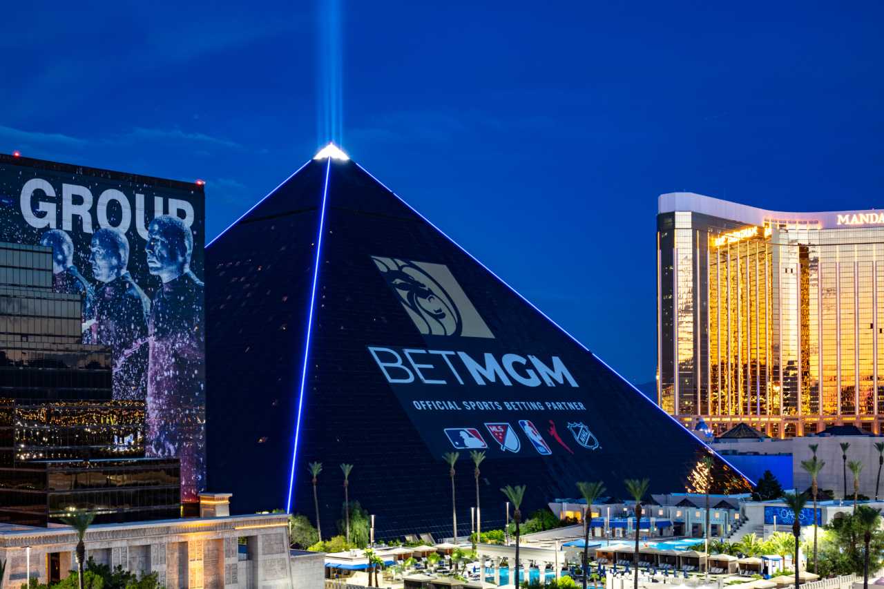 The new BetMGM ad wrap on the Luxor hotel in the evening with blue lighting.