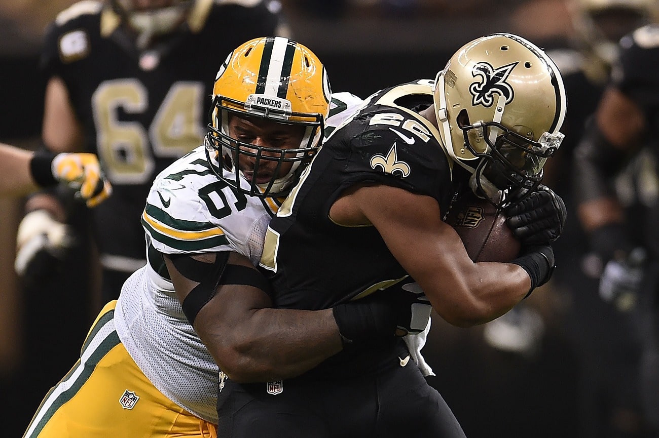 Mark Ingram #22 of the New Orleans Saints is brought down by Mike Daniels #76 of the Green Bay Packers during a game at the Mercedes-Benz Superdome on October 26, 2014 in New Orleans, Louisiana.