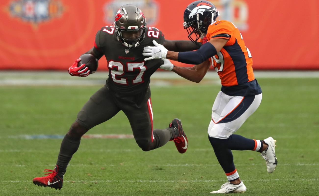 Ronald Jones of Tampa Bay Buccaneers rushes past Bryce Callahan of Denver Broncos at Empower Field September 2020