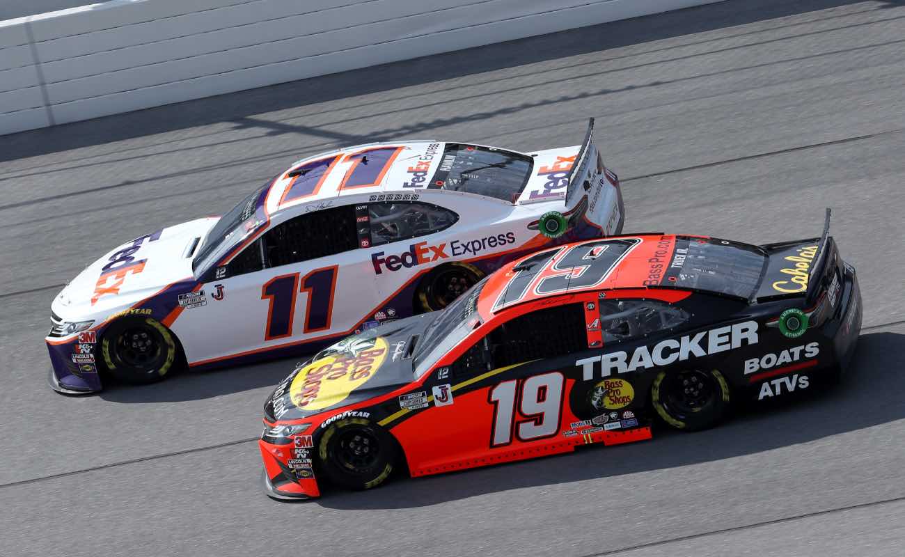 Denny Hamlin, driver of the #11 FedEx Express Toyota, and Martin Truex Jr., driver of the #19 Bass Pro Shops Toyota, race during NASCAR Cup Series YellaWood 500