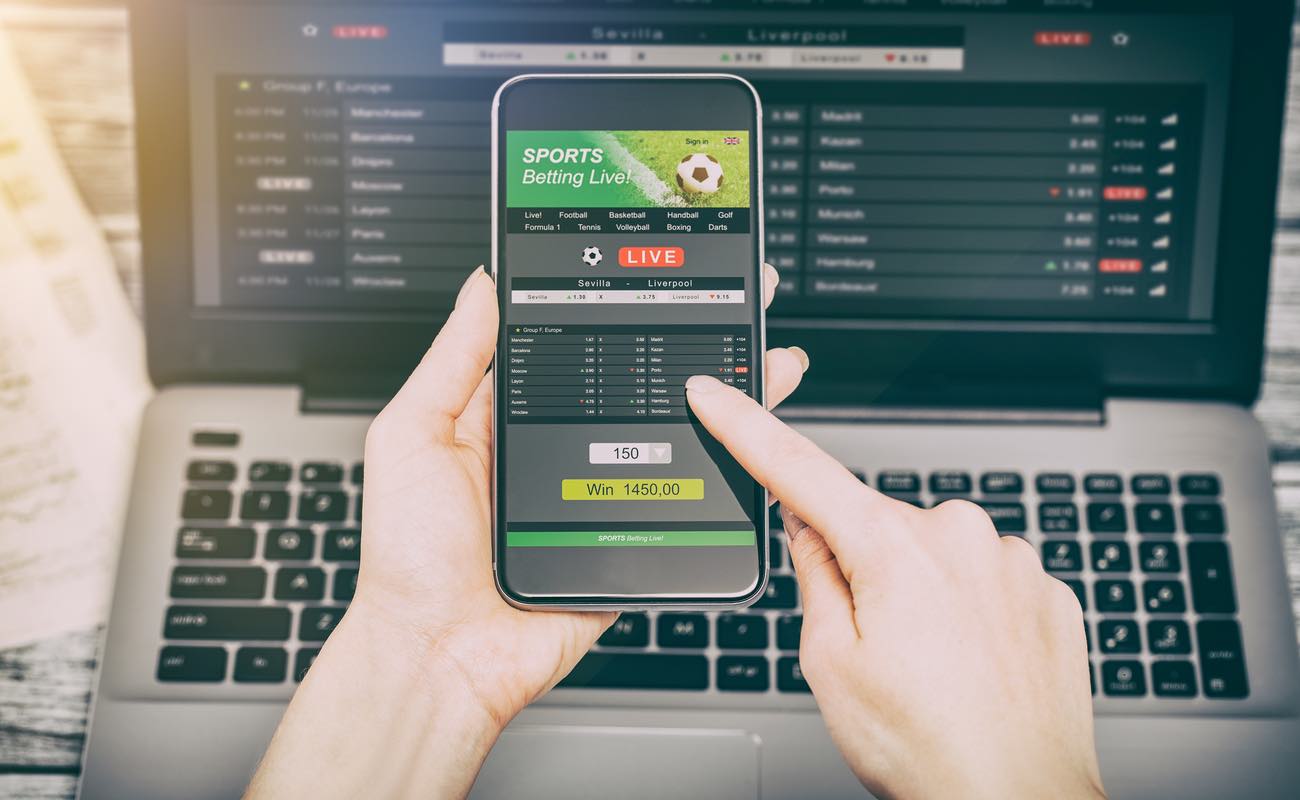 Man placing a sports bet on a mobile phone