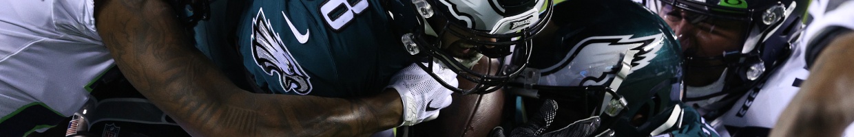 Dallas Goedert of the Philadelphia Eagles is tackled by members of the Seattle Seahawks. Photo by Elsa/Getty Images