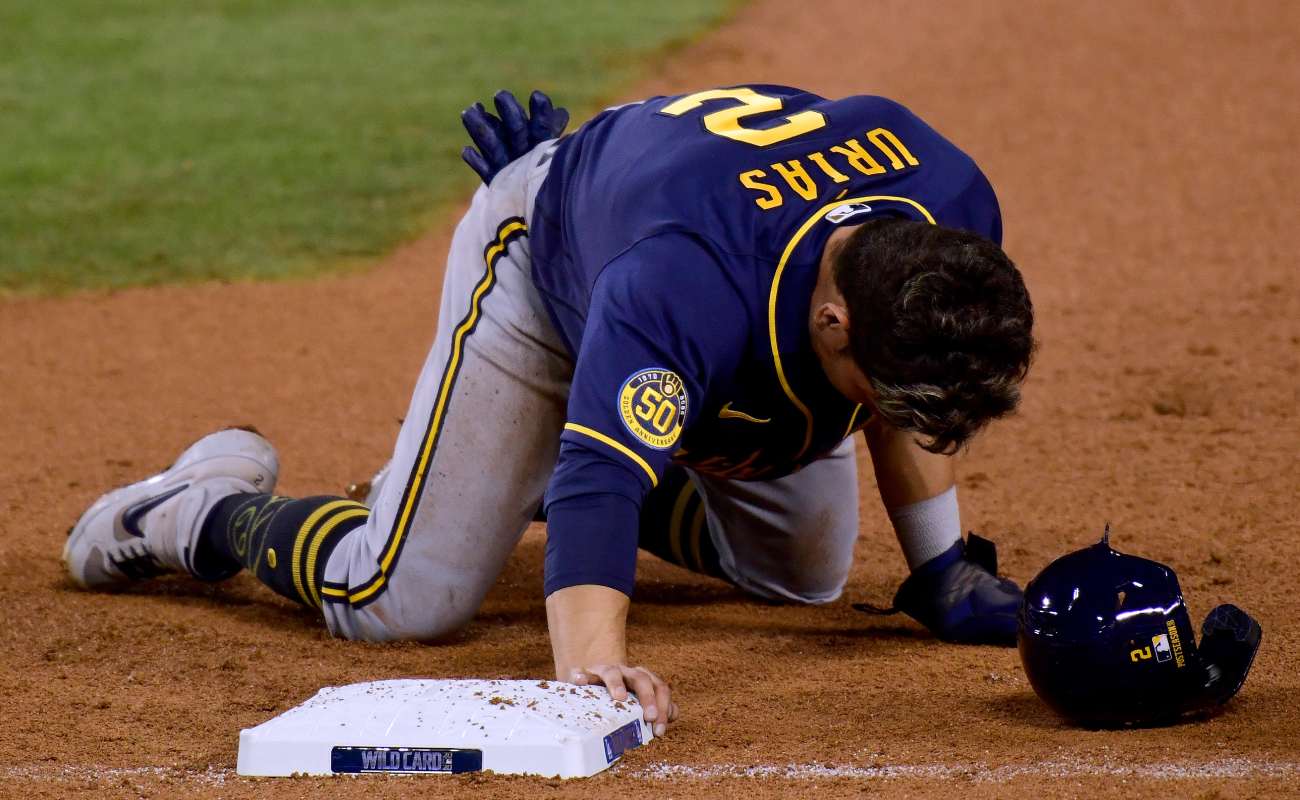 Luis Urias of the Milwaukee Brewers collapses to his knees after he is picked off at first base. Photo by Harry How/Getty Images