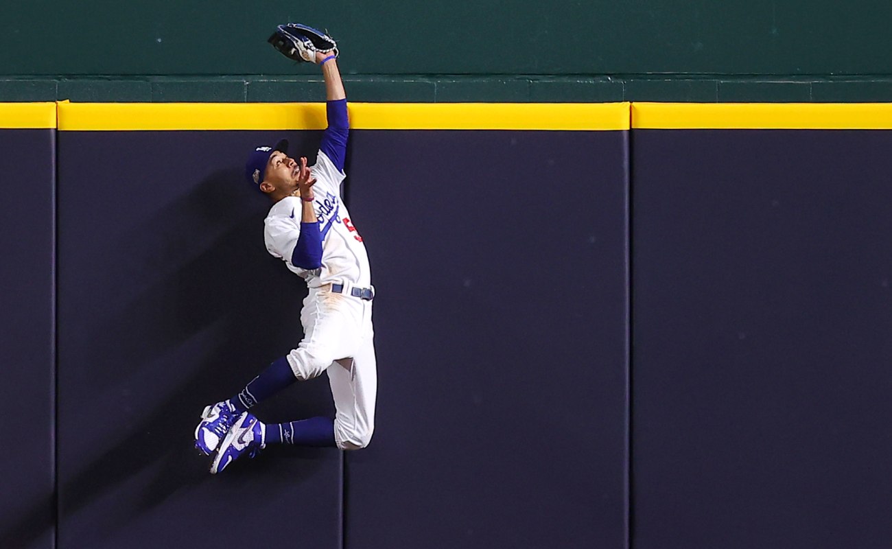 Mookie Betts of the Los Angeles Dodgers slides towards the plate against Dansby Swanson of the Atlanta Braves. Photo by Ron Jenkins/Getty Images