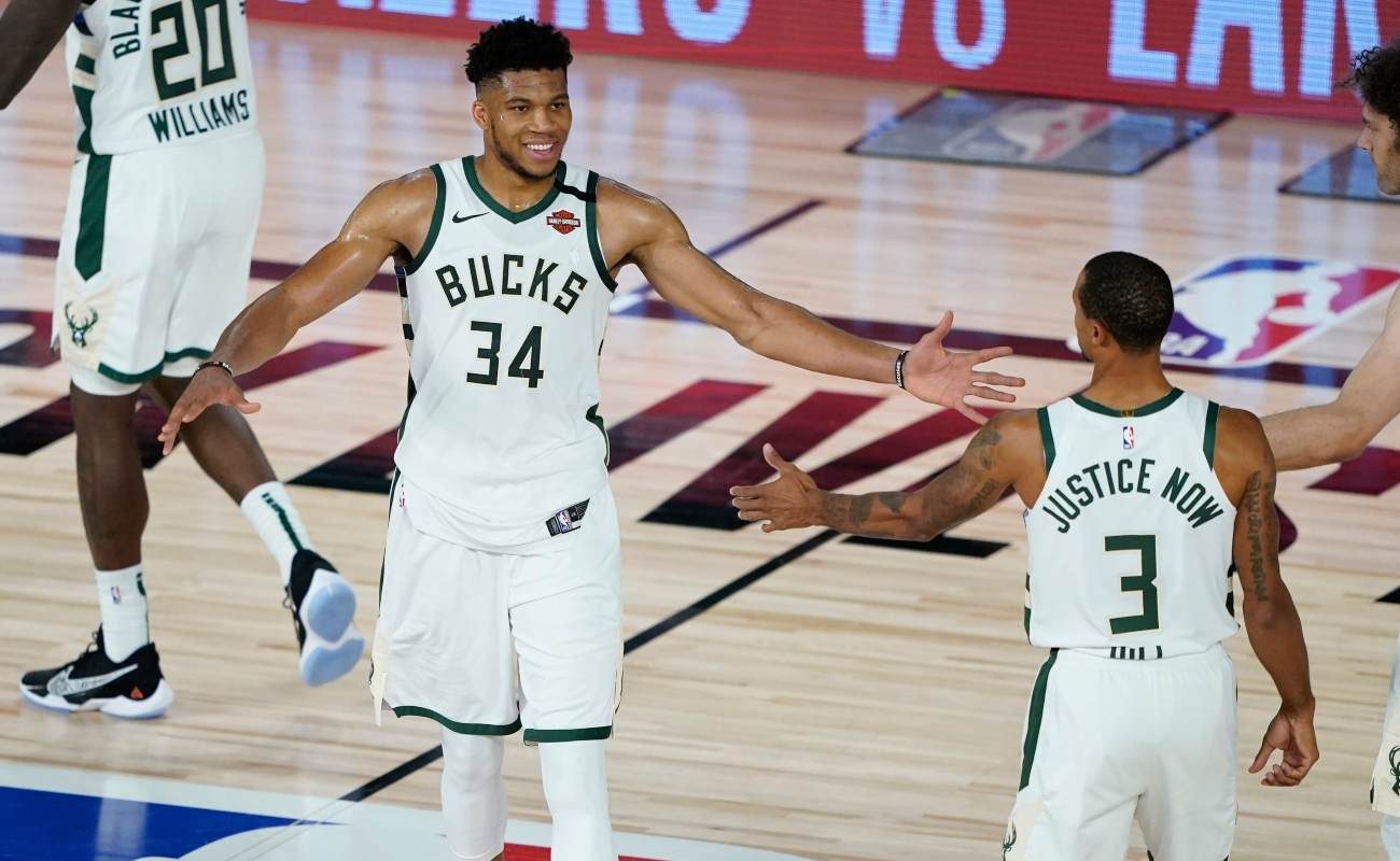 Giannis Antetokounmpo #34 of the Milwaukee Bucks celebrates with George Hill #3 and Robin Lopez #42 the team's win over the Orlando Magic in an NBA basketball first round playoff game on August 20, 2020 in Lake Buena Vista, Florida. (Photo by Ashley Landis - Pool/Getty Images)
