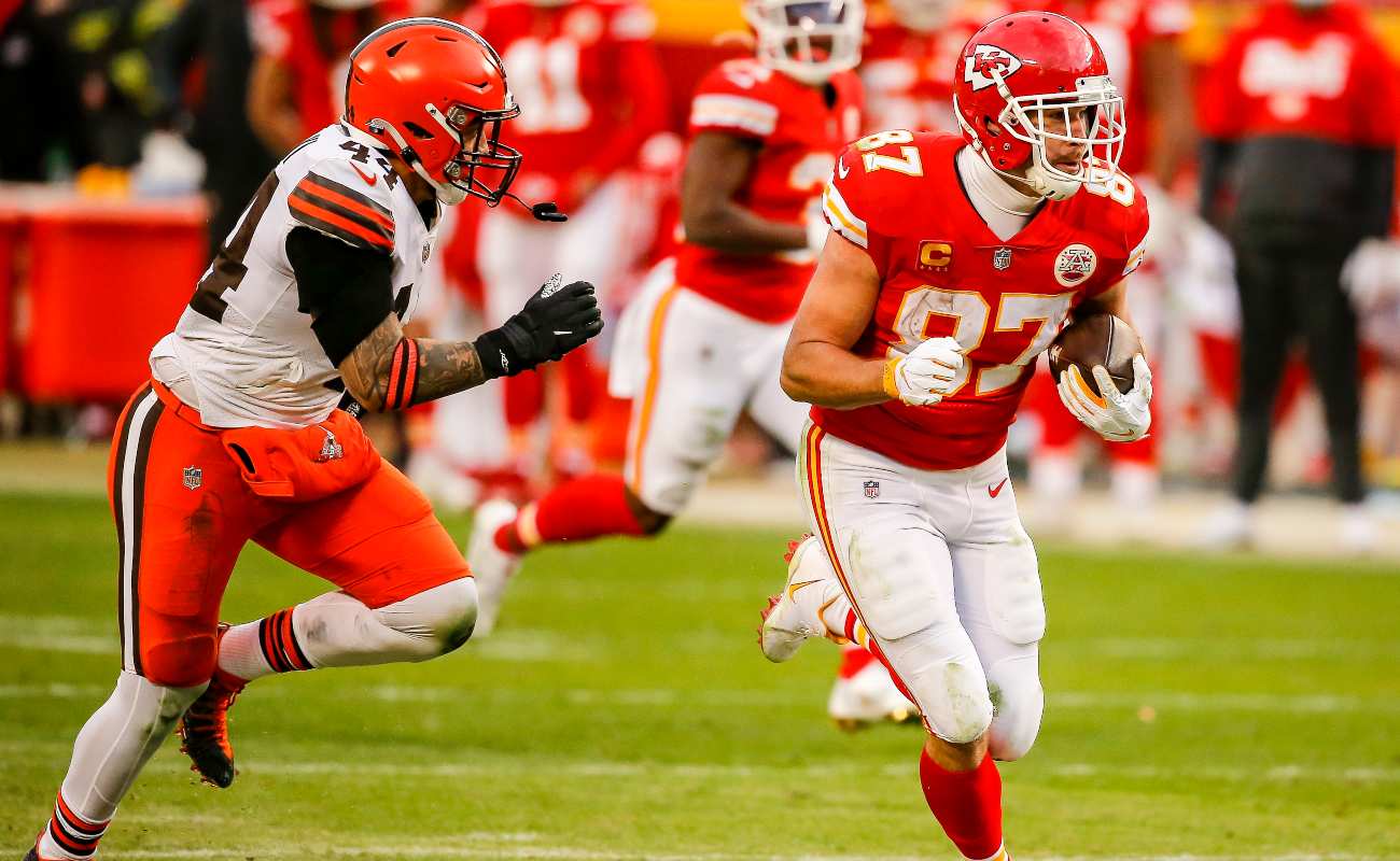 Travis Kelce #87 of the Kansas City Chiefs runs after a pass catch behind Sione Takitaki #44 of the Cleveland Browns in the fourth quarter of the AFC Divisional Playoff at Arrowhead Stadium on January 17, 2021 in Kansas City, Missouri. (Photo by David Eulitt/Getty Images)