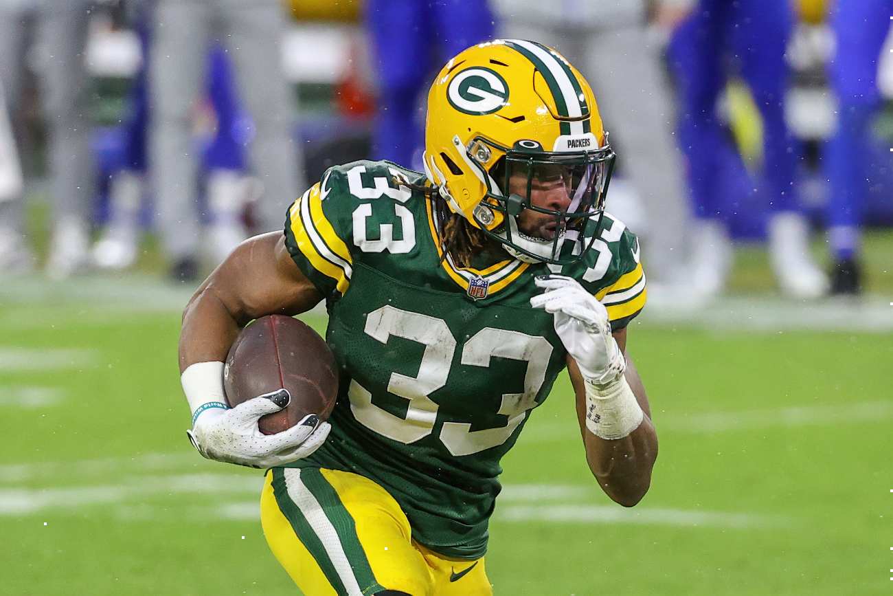 GREEN BAY, WISCONSIN - JANUARY 16: Aaron Jones #33 of the Green Bay Packers runs with the ball in the second quarter against the Los Angeles Rams during the NFC Divisional Playoff game at Lambeau Field on January 16, 2021 in Green Bay, Wisconsin. (Photo by Dylan Buell/Getty Images)