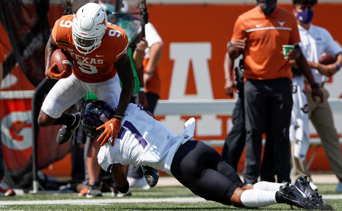 AUSTIN, TEXAS - OCTOBER 03: Al'Vonte Woodard #9 of the Texas Longhorns is tackled by Trevon Moehrig #7 of the TCU Horned Frogs in the third quarter at Darrell K Royal-Texas Memorial Stadium on October 03, 2020 in Austin, Texas. (Photo by Tim Warner/Getty Images)