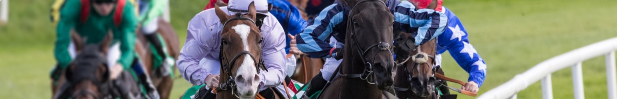 Horses racing down a track.